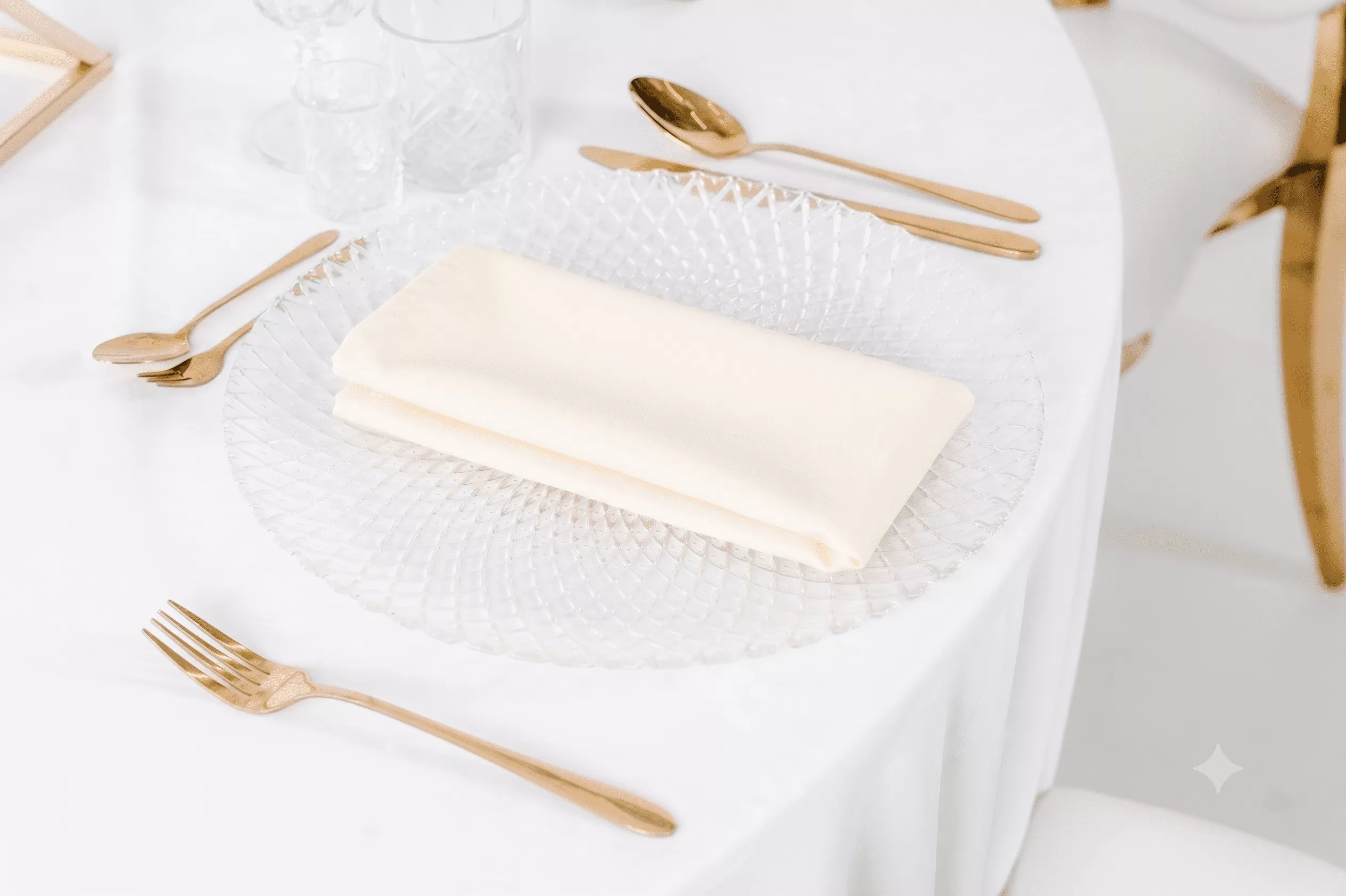 Gładka serwetka materiałowa w kolorze masełkowym (jasnożółtym, maślanym) ułożona na talerzu, idealna na wynajem na wesele i eleganckie przyjęcia.