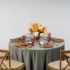 Okrągły stół weselny z szarym obrusem welurowym, srebrna zastawa i białe kwiaty w stylu Modern Classic – oferta wynajmu tekstyliów premium na eventy
