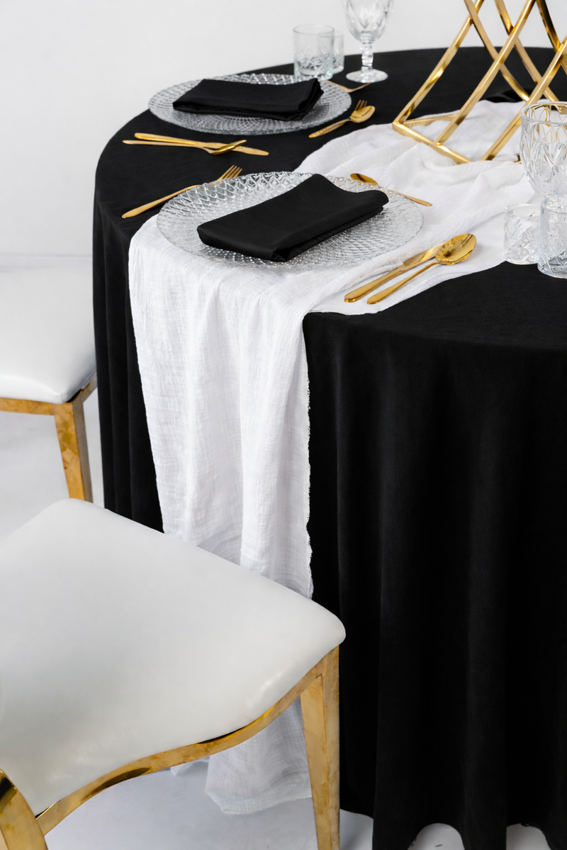 Biały bieżnik muślinowy o gniecionej strukturze, artystycznie udrapowany na weselnym stole – klasyczna dekoracja w stylu Modern Minimalist, wynajem tekstyliów eventowych