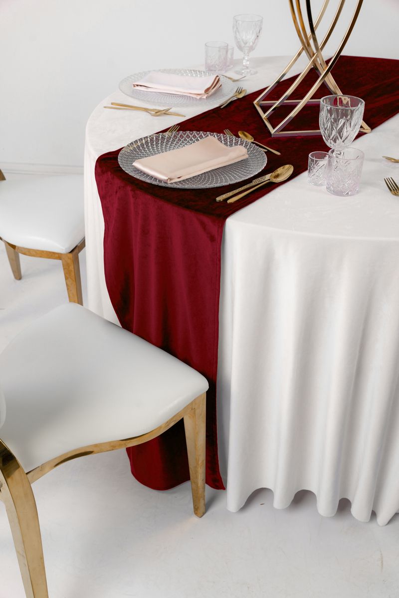 Luksusowy bieżnik welurowy w kolorze bordowym na białym obrusie ze złotą zastawą – styl Old Money i Royal Wedding, wypożyczalnia tekstyliów eventowych