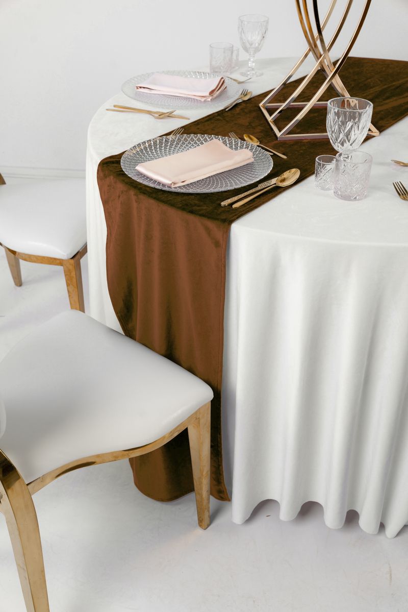 Dekoracja stołu weselnego z brązowym bieżnikiem welurowym, złotą zastawą i świecami w kolorze kremowym – styl Quiet Luxury i Modern Rustic, wynajem tekstyliów premium