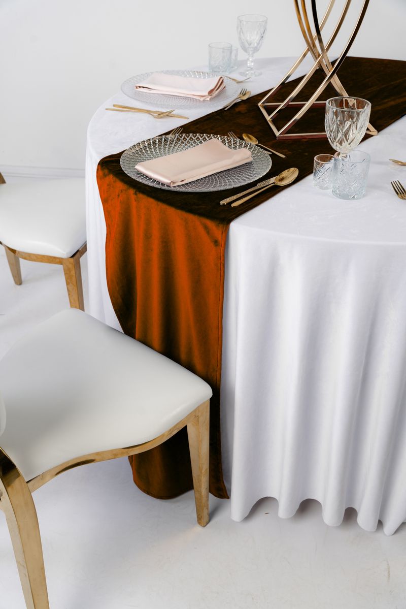 Miedziany bieżnik welurowy na stole weselnym w stylu Terracotta Luxe, złote sztućce i suszone kwiaty, wypożyczalnia dekoracji premium Copper Rust