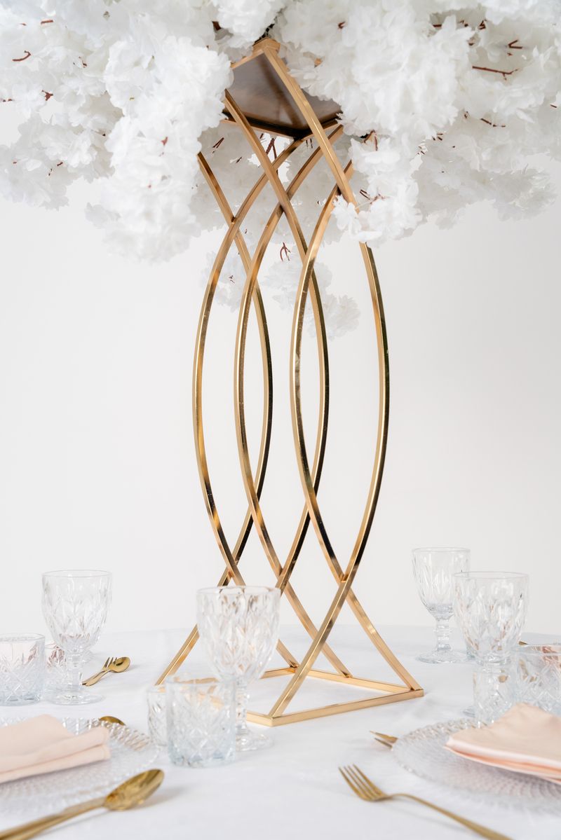 Kwietnik Rybka złoty w aranżacji glamour – wysoka dekoracja florystyczna na stół weselny, która nie zasłania gości.