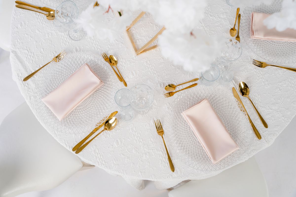 Detal białego obrusu żakardowego o wypukłej strukturze – luksusowa tkanina eventowa z geometrycznym splotem, matowy żakard premium na wynajem