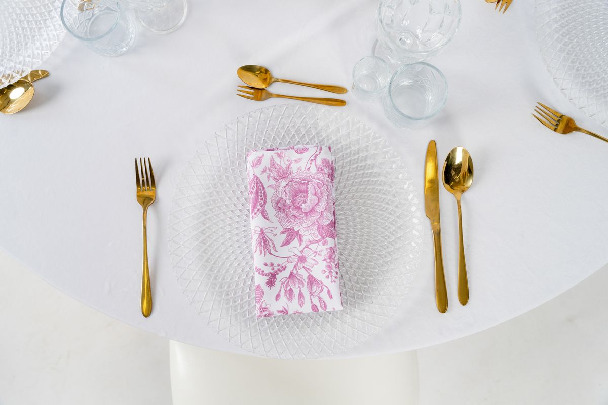 Serwetka w różowe kwiaty na talerzu ze złotymi sztućcami – elegancka dekoracja stołu weselnego w stylu romantic garden
