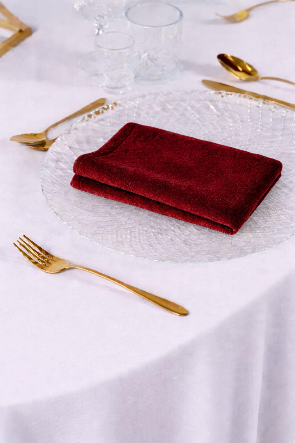 Elegancka aranżacja stołu weselnego z bordowymi serwetkami welurowymi i złotymi sztućcami – styl Moody Romantic i Old Money, luksusowy wynajem tekstyliów eventowych