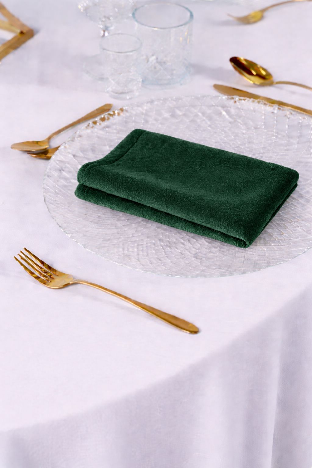 Dekoracja stołu weselnego z serwetkami welurowymi w kolorze butelkowej zieleni, złota zastawa i białe kwiaty – styl Forest Luxury i Modern Glamour, wypożyczalnia tekstyliów premium