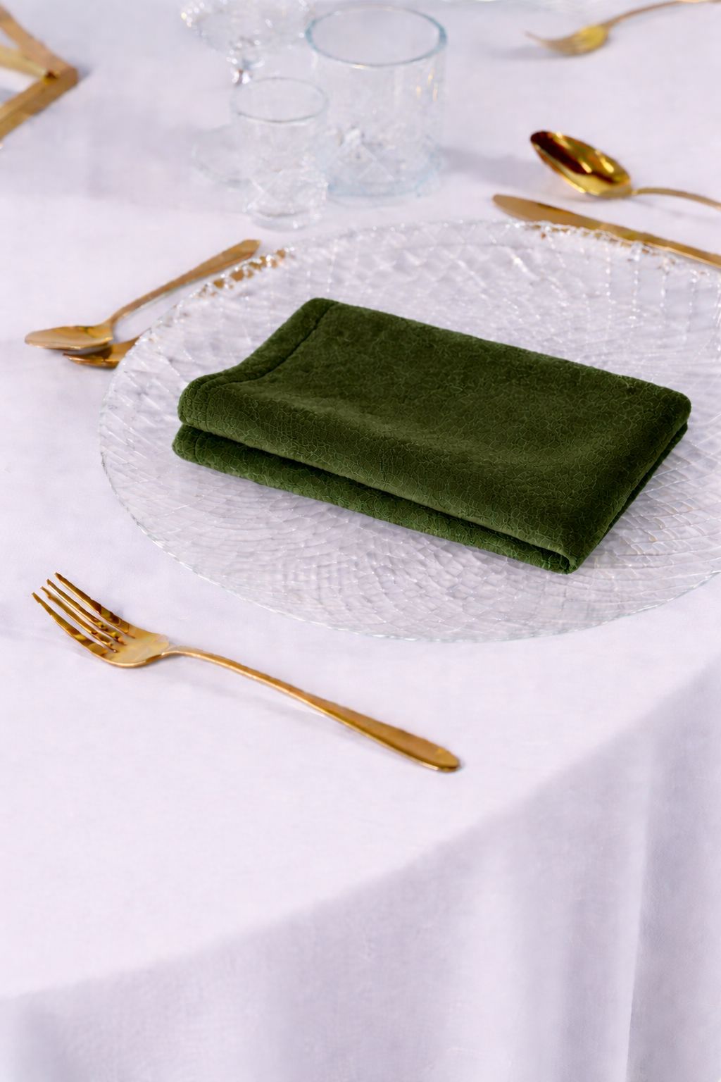 Luksusowa dekoracja stołu weselnego z serwetkami welurowymi w kolorze ciemny mech, miedziane sztućce i plastry drewna – styl Forest Core i Moody Romance, profesjonalna wypożyczalnia tekstyliów