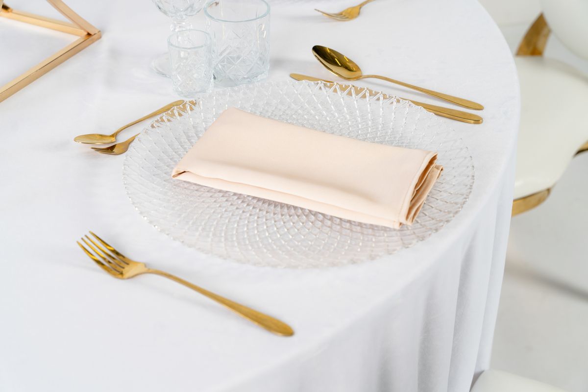 Detal szampańskiej serwetki satynowej o perłowym połysku – beżowe tekstylia eventowe premium, wysoka gramatura materiału, oferta wypożyczalni dekoracji
