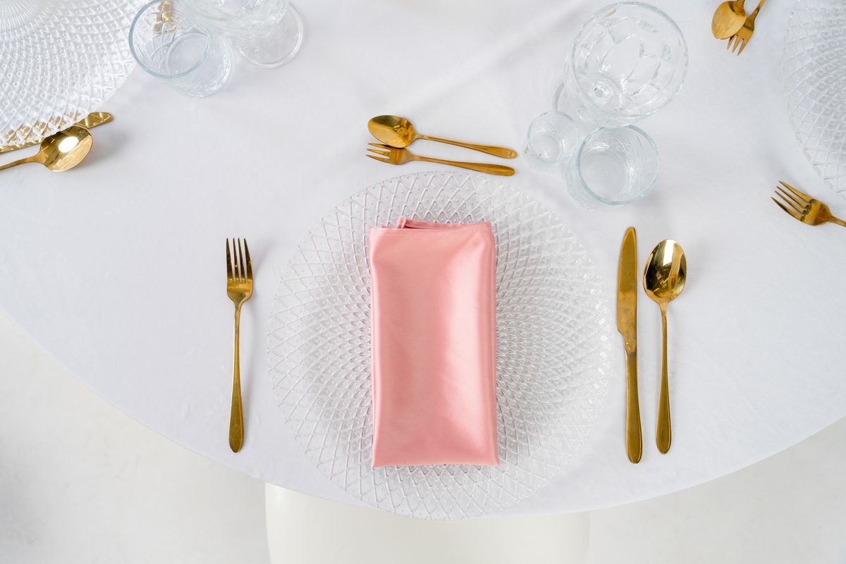 Kolorowe serwetki satynowe na wynajem – luksusowe tekstylia eventowe o wysokim połysku w odcieniach złota, butelkowej zieleni, burgundu i szampana.