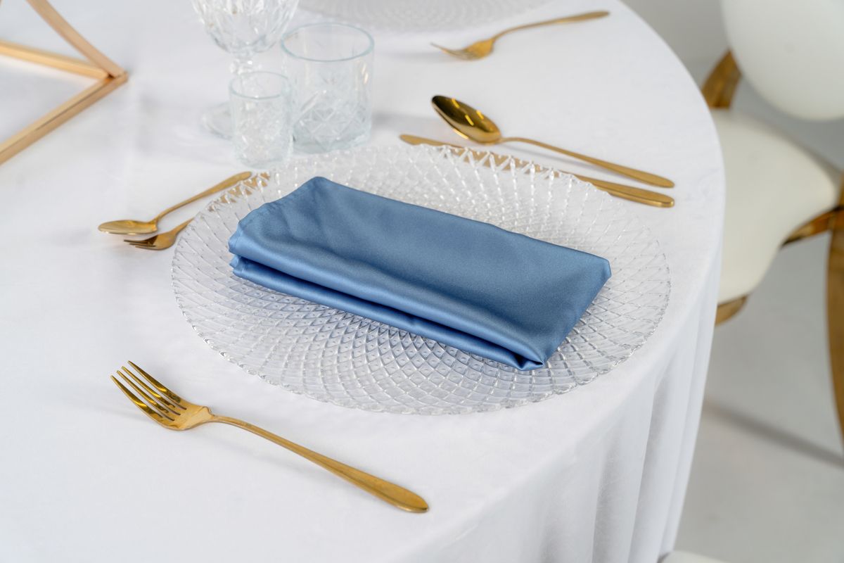 Detal błękitnej serwetki satynowej o atłasowym połysku – luksusowe tekstylia eventowe w kolorze brudnego błękitu, wysoka gramatura materiału