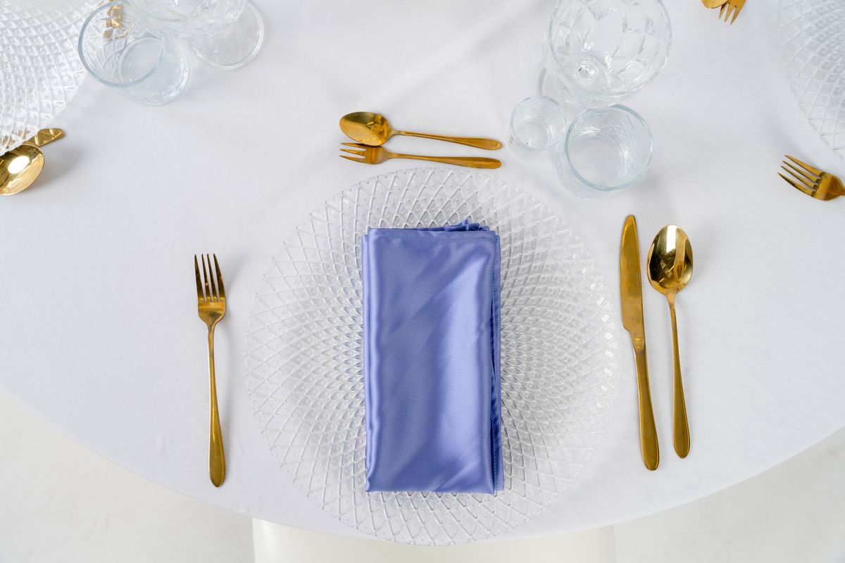 Detal granatowej serwetki satynowej o szlachetnym połysku – luksusowa tkanina Navy Blue na wynajem, eleganckie tekstylia bankietowe.