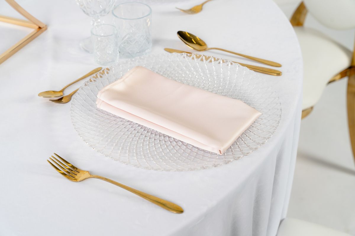 Detal kremowej serwetki z połyskującej satyny w odcieniu Ivory – luksusowe tekstylia bankietowe o wysokiej gramaturze, wypożyczalnia dekoracji